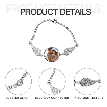 Silver photo bracelet with round locket and angel wings; lobster clasp shown