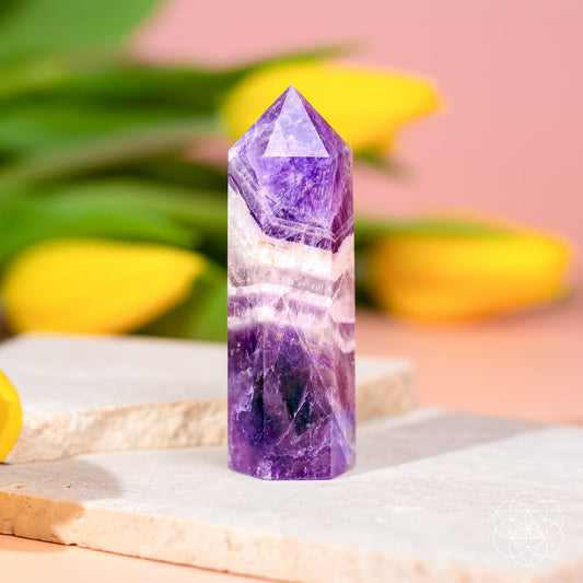 Amethyst crystal point with faceted purple body and white veining