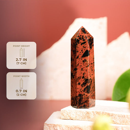 Mahogany obsidian point crystal with orange and black flecks, standing on a stone base
