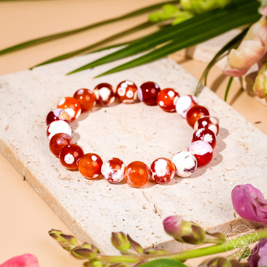 Beaded bracelet with orange and white round stones and shiny red accents