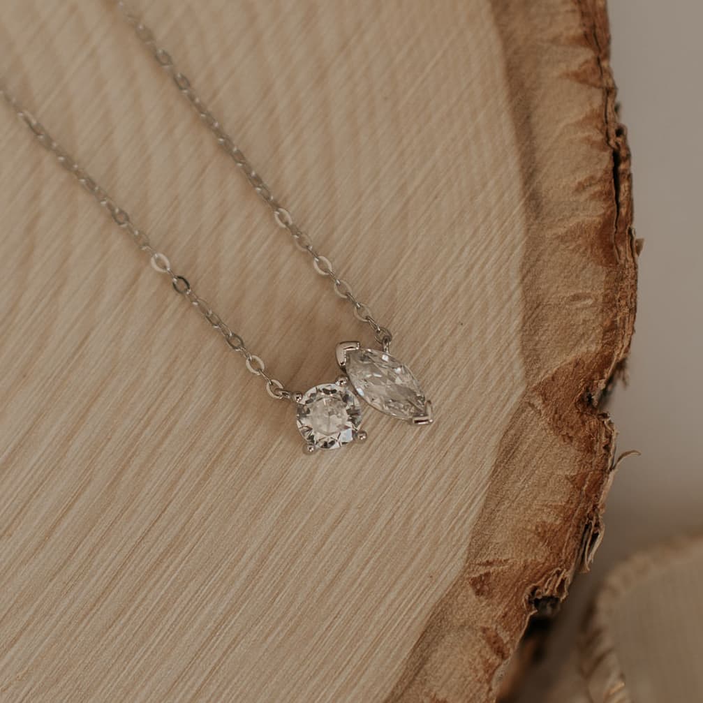 Silver necklace featuring clear round and marquise-cut stones on a fine chain