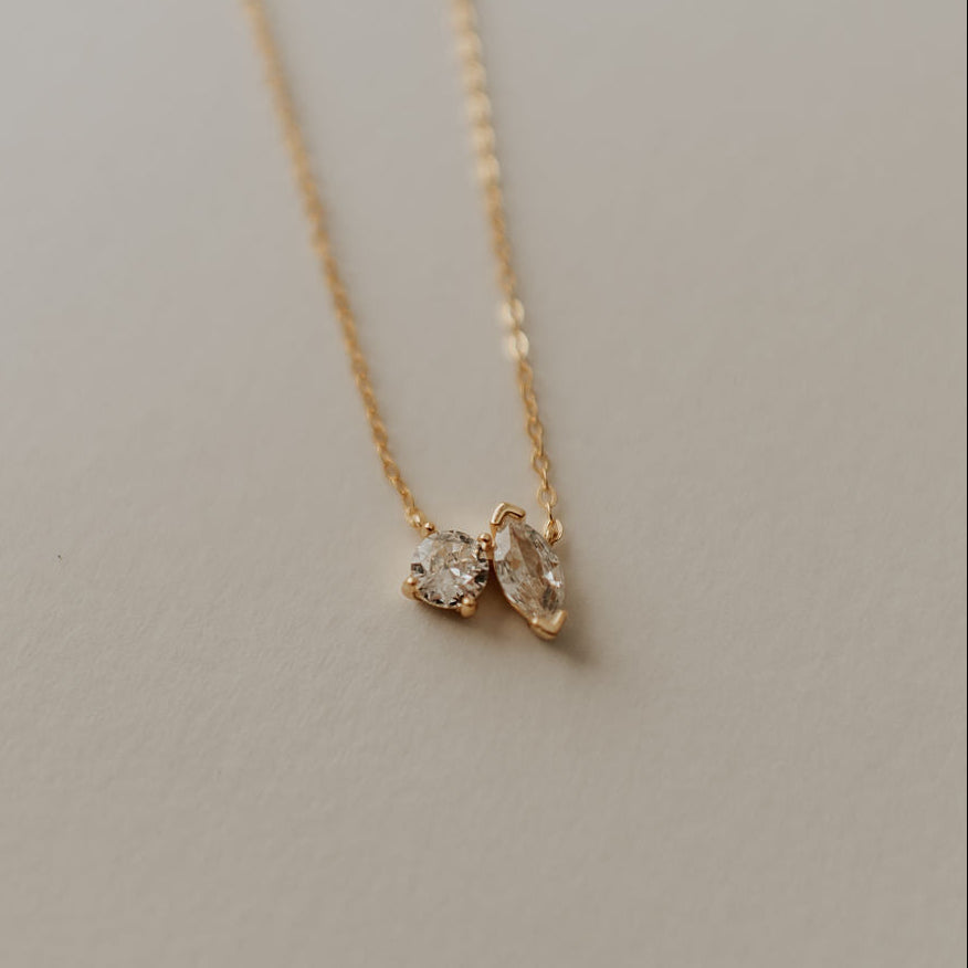 Gold necklace with round and marquise-cut clear stones on a fine chain