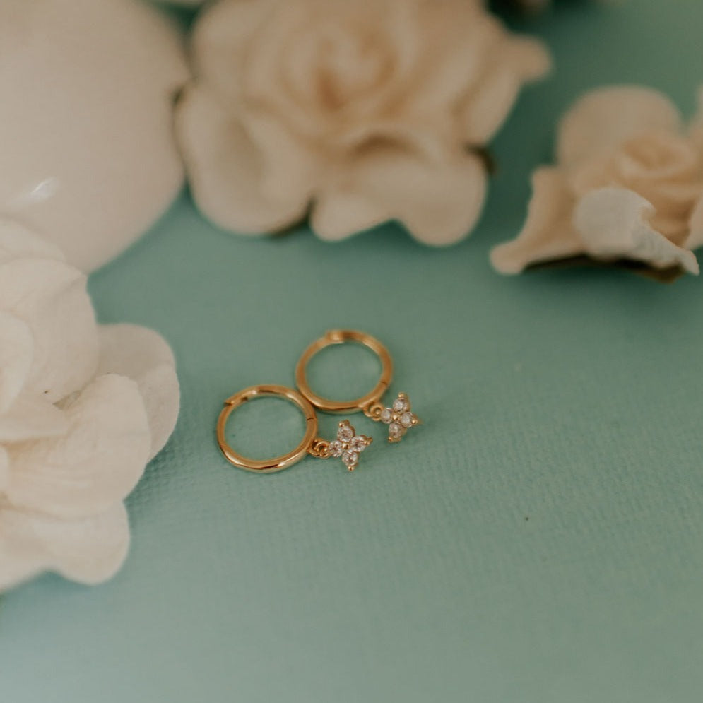 Pair of gold hoops with small sparkling flower charms