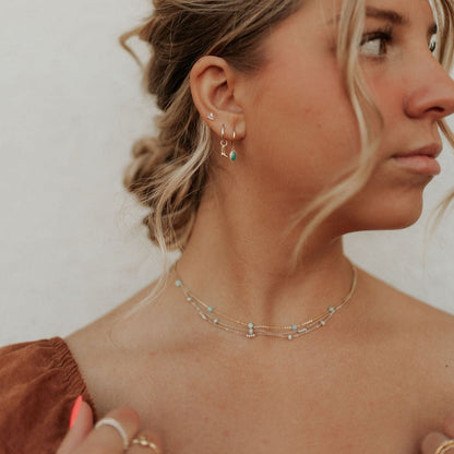 Layered gold-tone and turquoise necklaces worn at the neck
