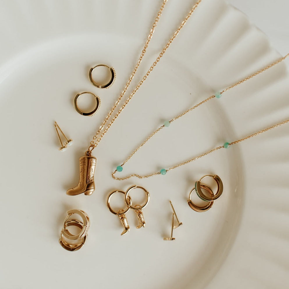 Gold-tone necklace with turquoise beads displayed among other jewelry