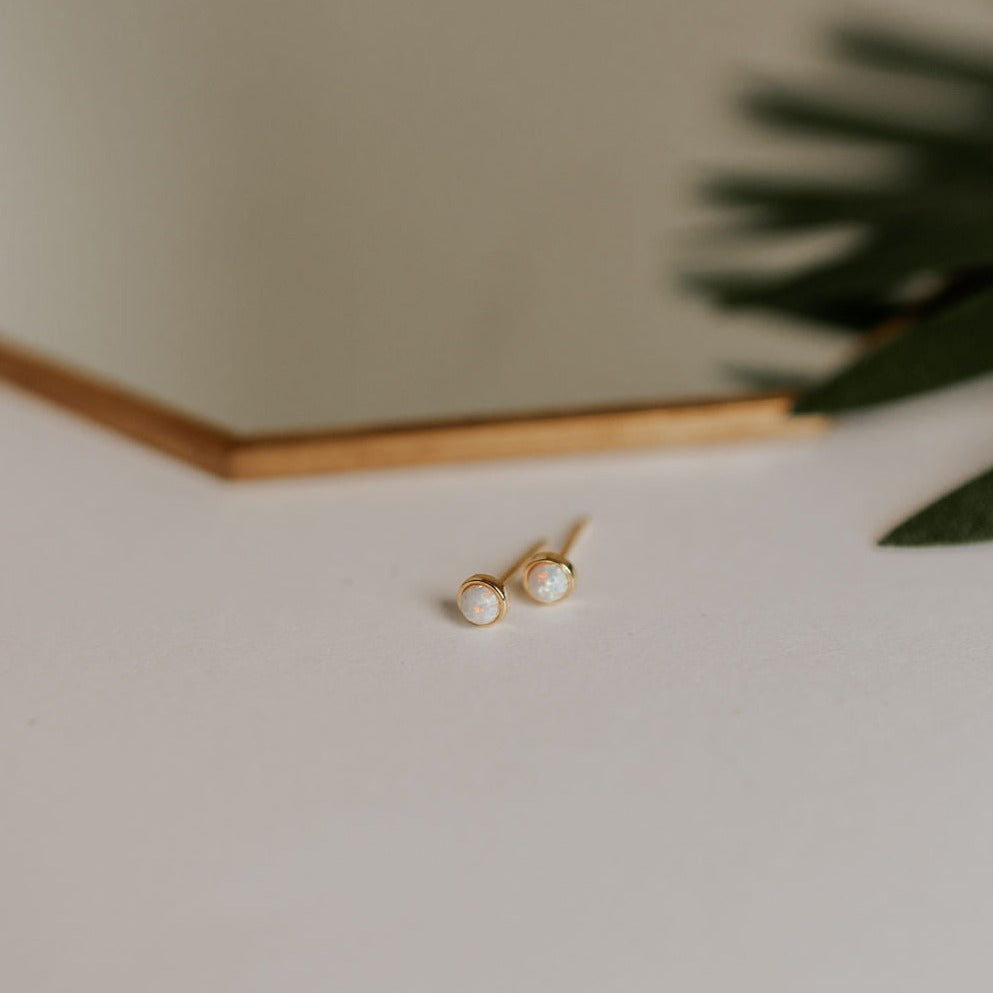 Small round opal studs in gold-tone settings