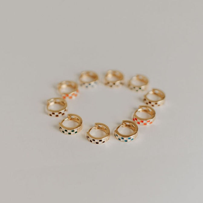 Gold-tone hoop earrings with checkered enamel in assorted colors, including blue and white