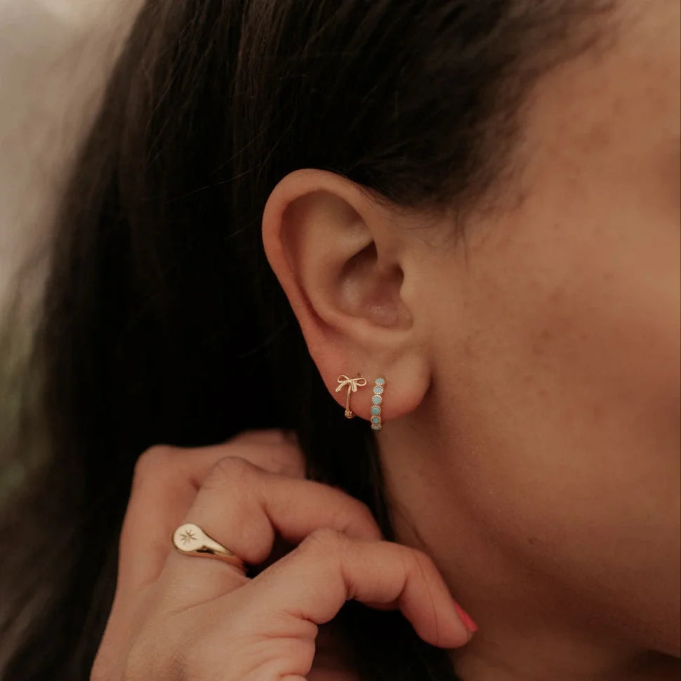 Gold-tone hoop earring with a vertical row of turquoise stones