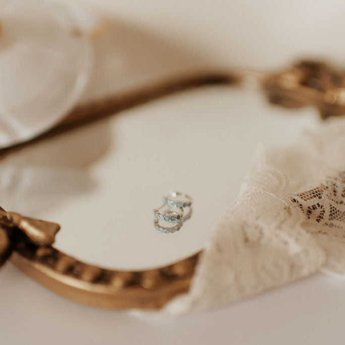 Silver-tone turquoise hoop earrings with rows of blue-green stones