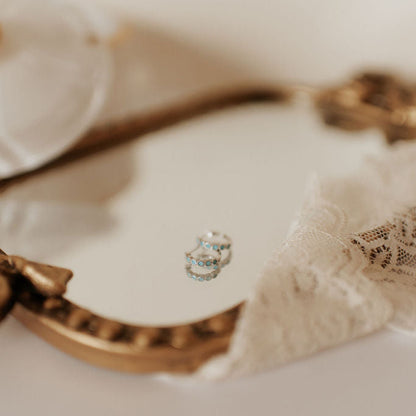 Silver-tone turquoise hoop earrings with rows of blue-green stones