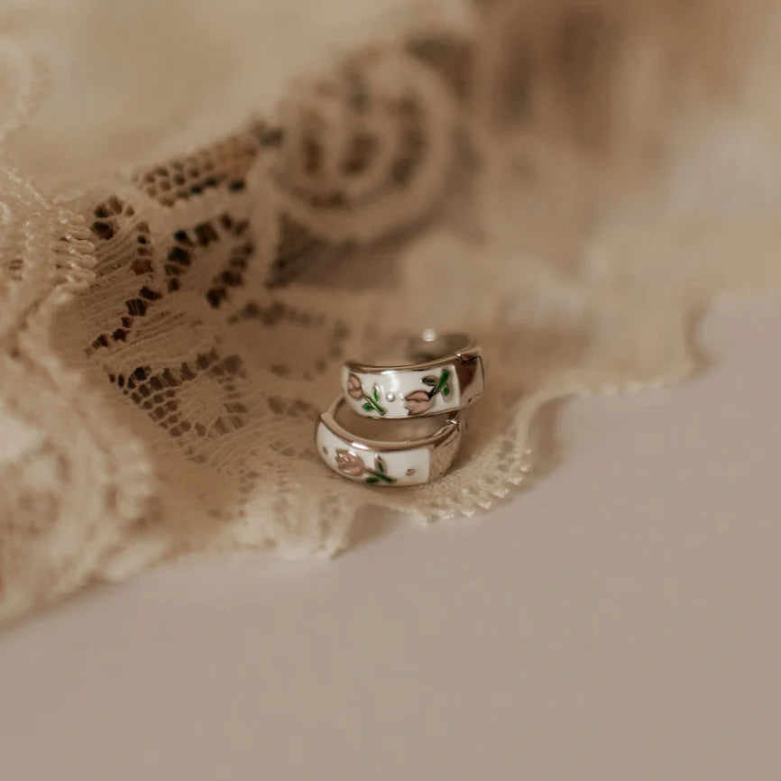 Silver enamel huggie hoop earrings with green and pink floral motifs