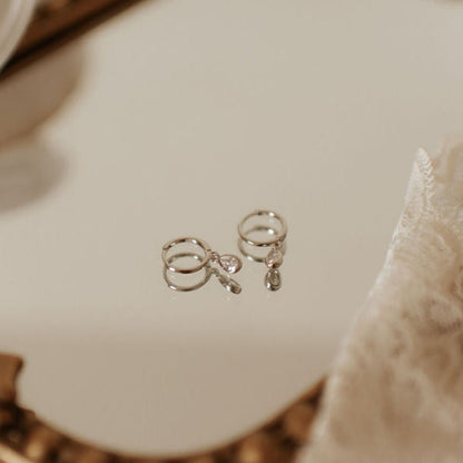 Pair of silver hoops with dangling teardrop stones.