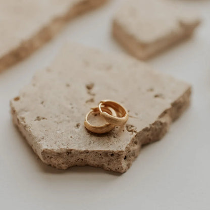 Pair of gold chunky brushed huggie hoop earrings, shown closed.