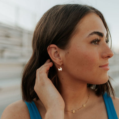 Gold vermeil hoop earring with a small hammered disc charm, worn on the ear