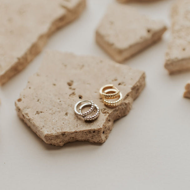 Rory huggie hoop earrings in gold and silver with ridged detailing