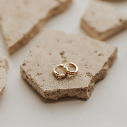 Pair of gold huggie hoops with ridged detailing