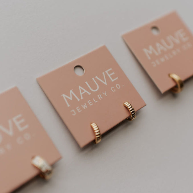 Gold ridged huggie hoops attached to a jewelry card