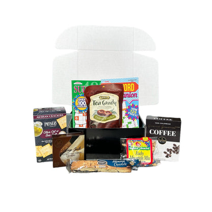 Care package gift box open with tea candy, coffee, crackers, cheese spread and snack mix