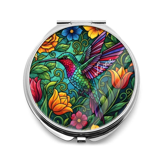 Silver compact mirror with a colorful hummingbird and floral design on the cover