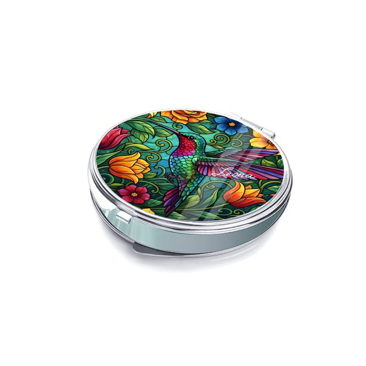 Silver compact mirror shown closed at an angle, with a hummingbird and floral cover