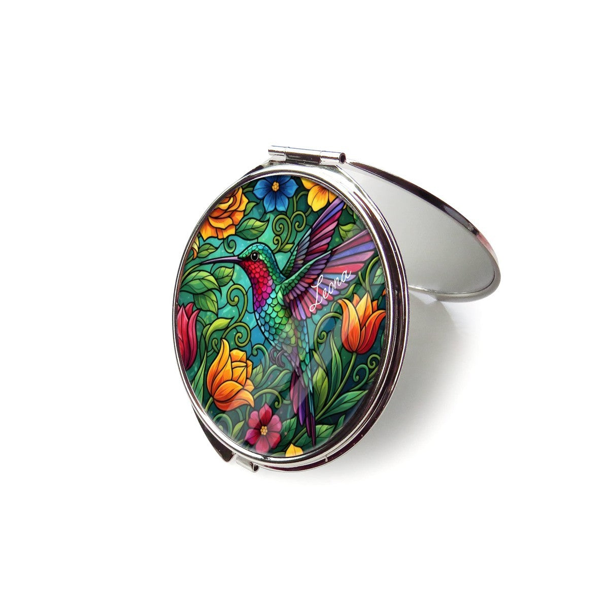Open silver compact mirror with hummingbird and floral artwork on the outer cover