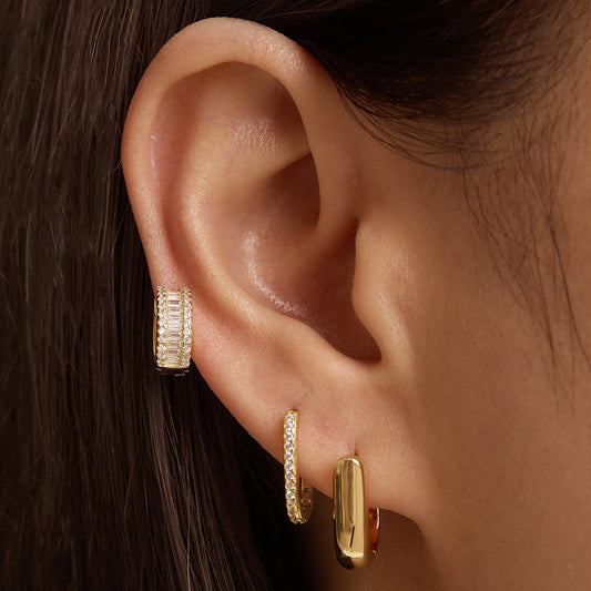 Gold oval hoop earring on ear, small rounded profile
