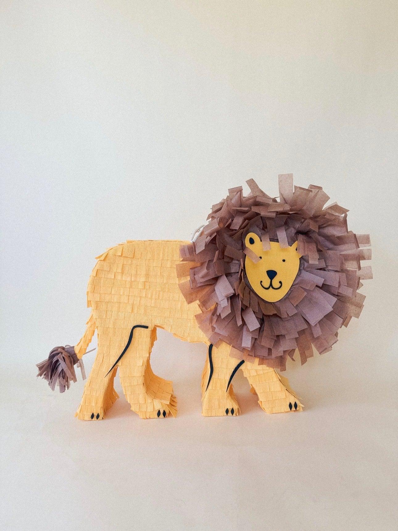 Piñata de león completa con melena morada y cuerpo beige, cara amarilla mirando al frente