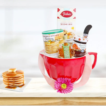 Red mug gift basket with scone mix, waffle mix, maple syrup bottle, and small baking items