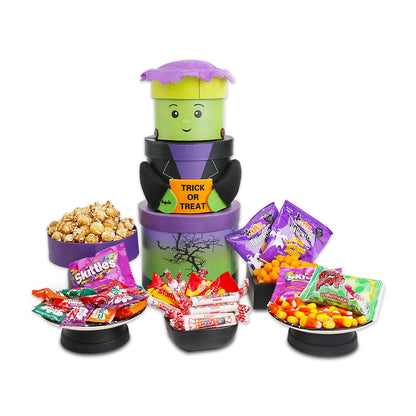 Stacked Halloween treat tower with green character head and candy packs