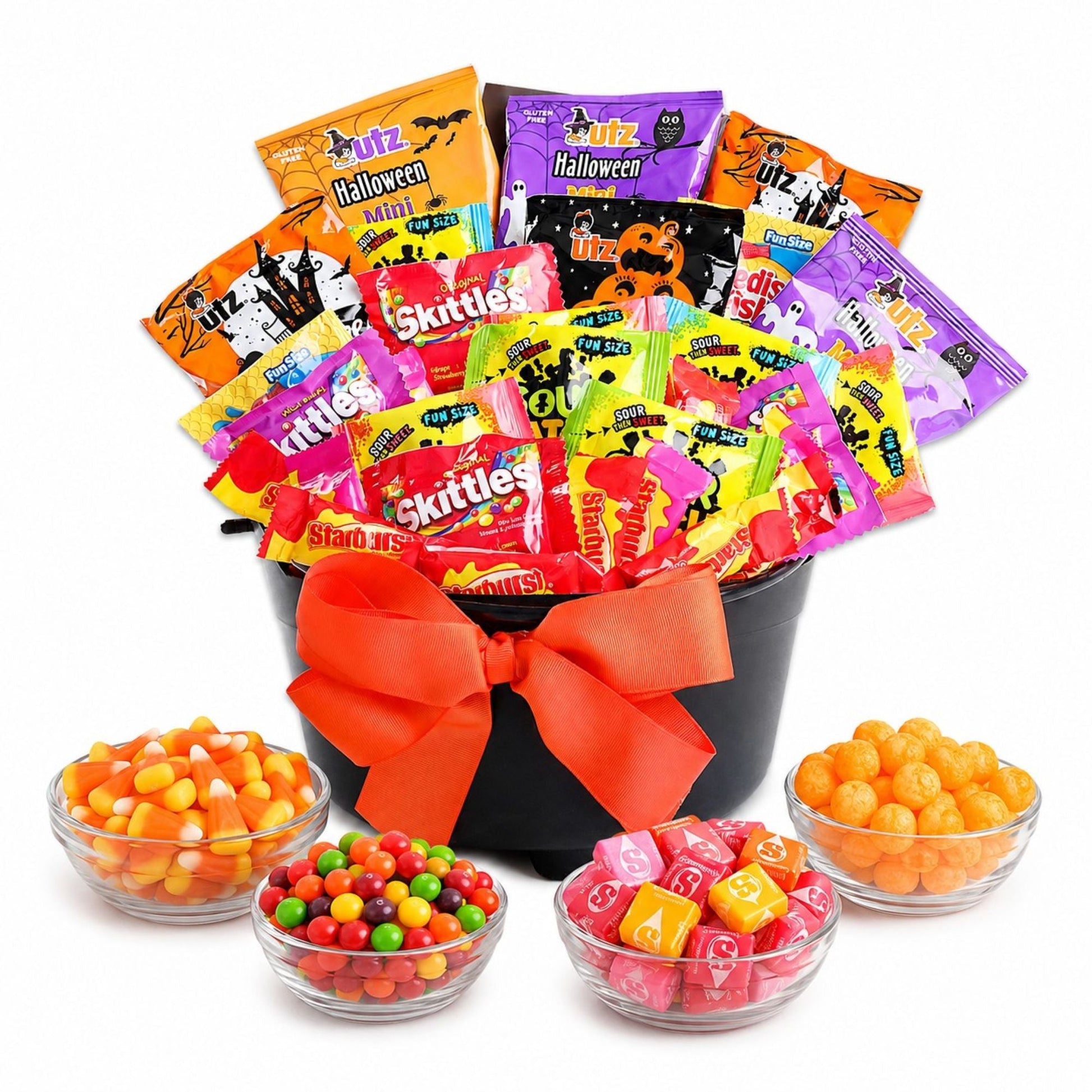 Halloween treat gift basket in black cauldron with orange bow, assorted candy bags