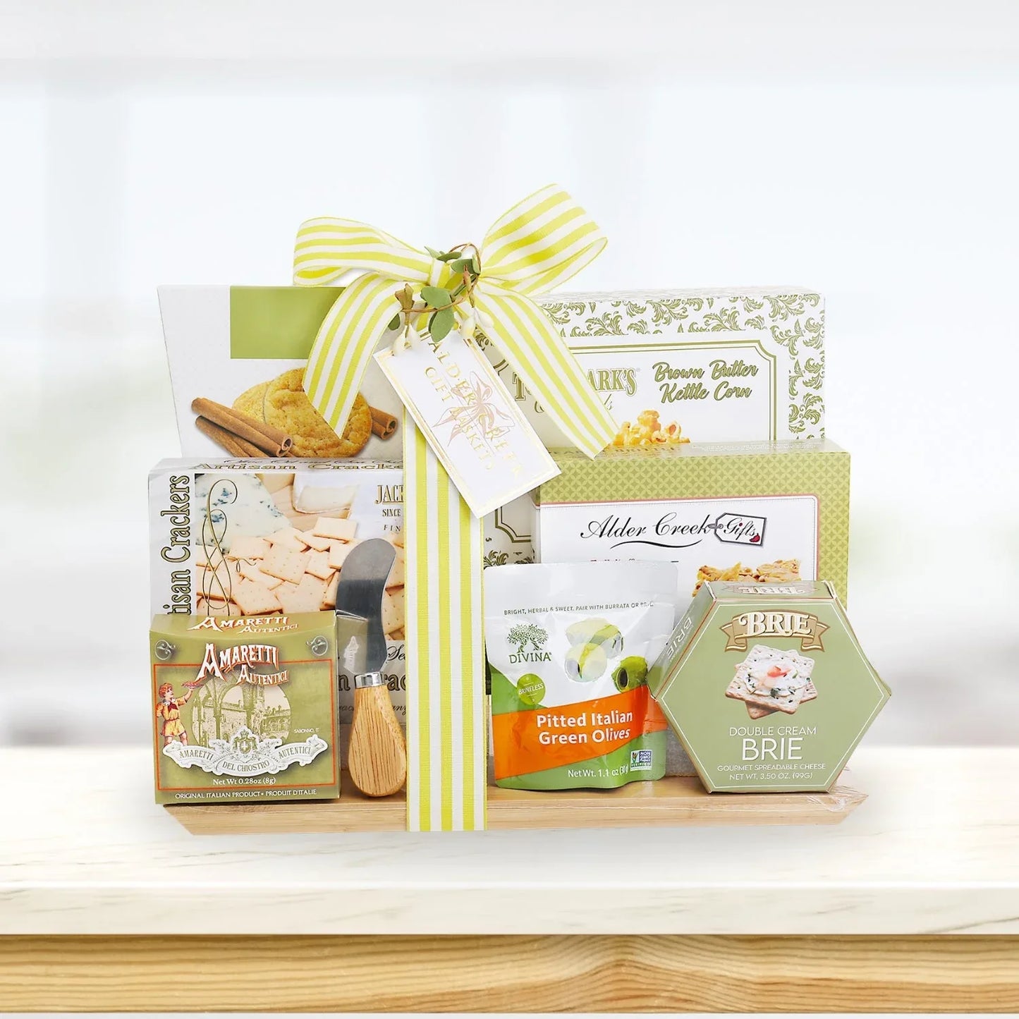 Wrapped charcuterie board gift basket with crackers, brie, and olive snacks