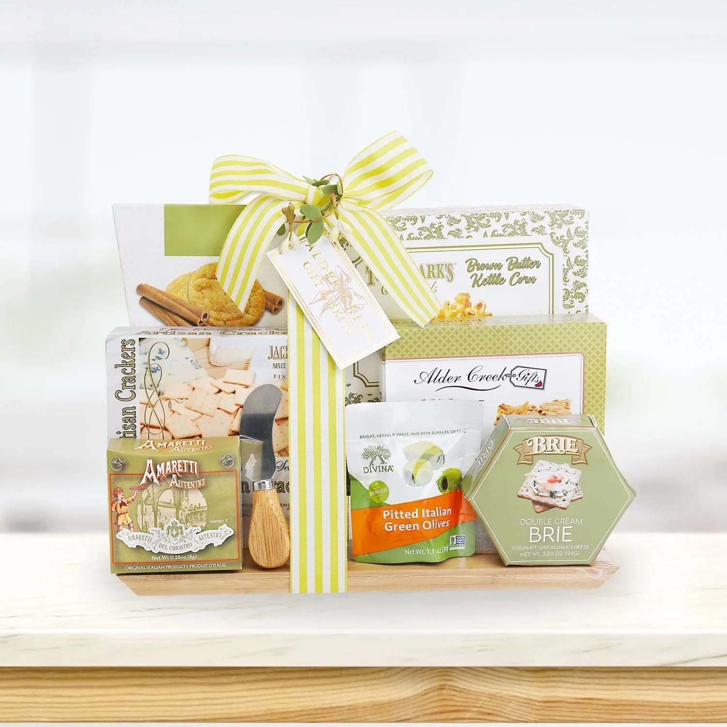 Wrapped charcuterie board gift basket with crackers, brie, and olive snacks