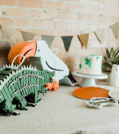 Tropical toucan piñata on party table, orange beak and white body with handle loop