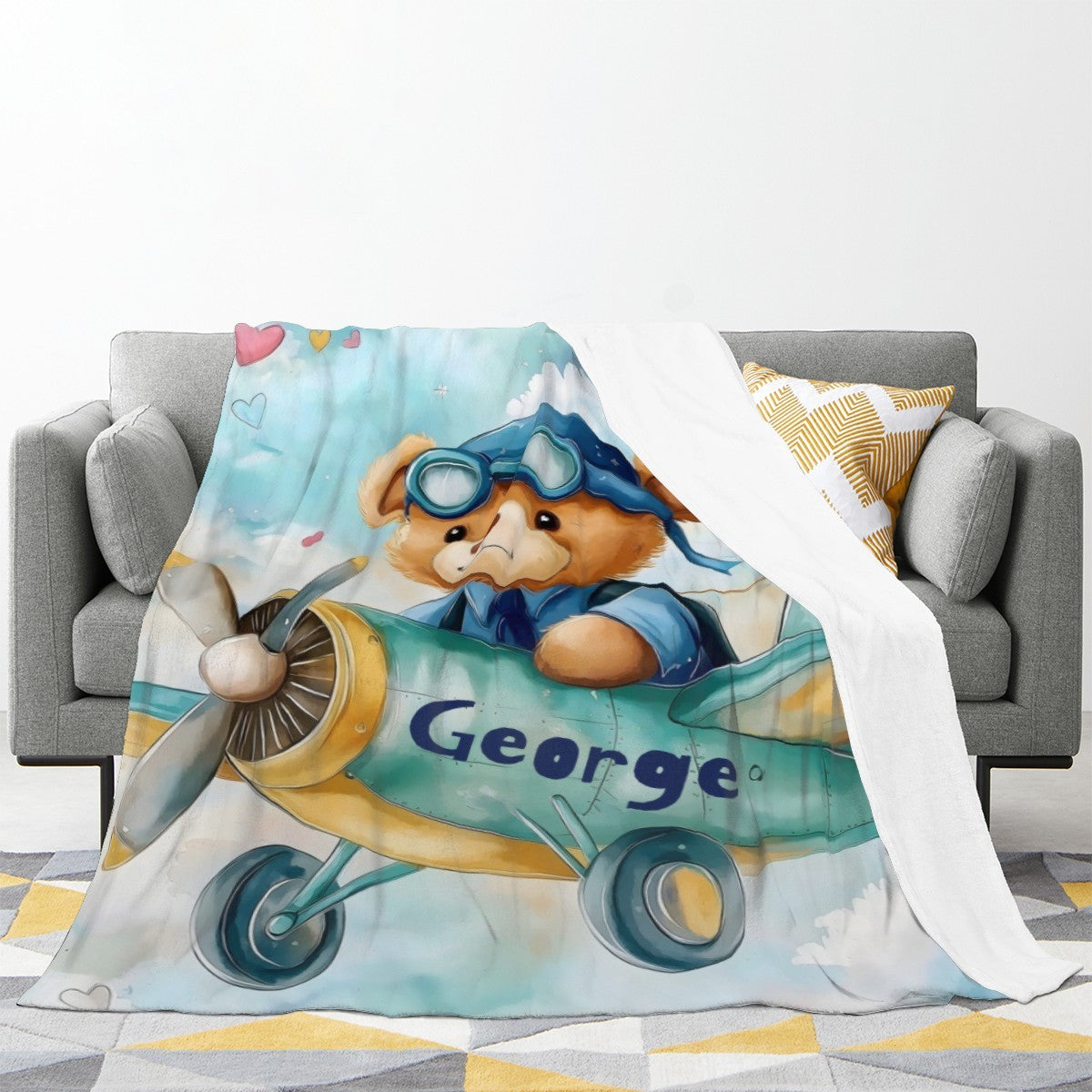 Pilot teddy bear blanket on couch, light blue airplane design with George name