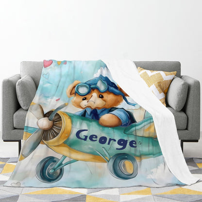 Pilot teddy bear blanket on couch, light blue airplane design with George name