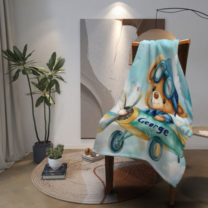 Pilot teddy bear blanket draped over chair, light blue with George name