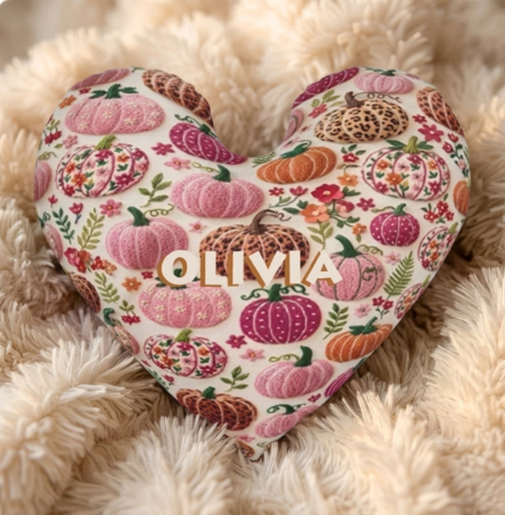 Close-up of heart-shaped pillow with cream pumpkin floral pattern and OLIVIA