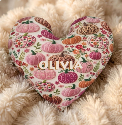 Close-up of heart-shaped pillow with cream pumpkin floral pattern and OLIVIA