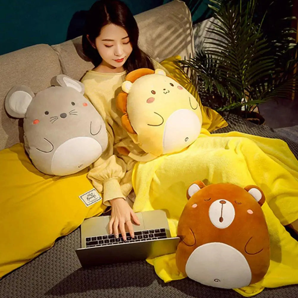 Plush animal cushion blankets on a bed: gray mouse, yellow bear, and pale yellow chick cushion