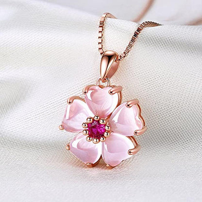 Rose-gold sakura pendant necklace with pink flower petals and fuchsia center stone.