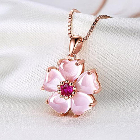 Rose-gold sakura pendant necklace with pink flower petals and fuchsia center stone.
