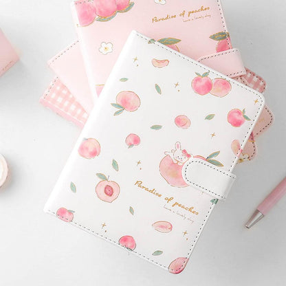 Pink and white peach notebook with cute rabbit graphic, side strap, and stitched border