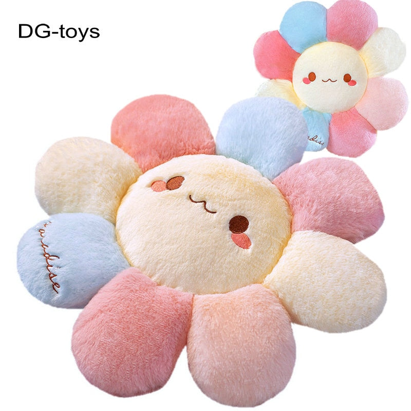 Plush flower pillow with rounded petals in pink, blue, and cream, smiling face