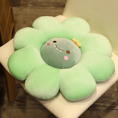 Light green plush flower pillow with gray animal face, stitched smile, and pink cheek accents