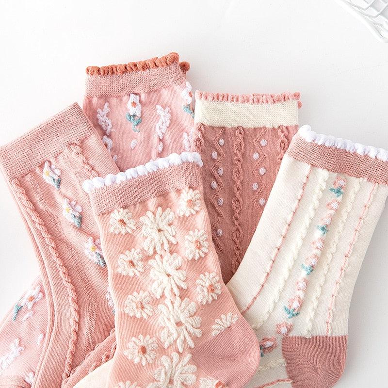 Floral embroidered socks with ribbed cuffs and daisy patterns; pink, mauve, and white