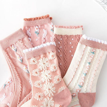 Floral embroidered socks with ribbed cuffs and daisy patterns; pink, mauve, and white