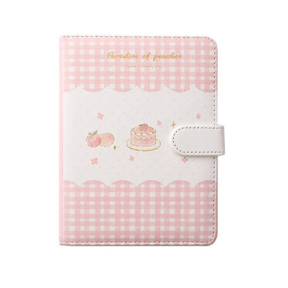 Peach-themed notebook cover with pink gingham border, cake and peach graphics, and strap