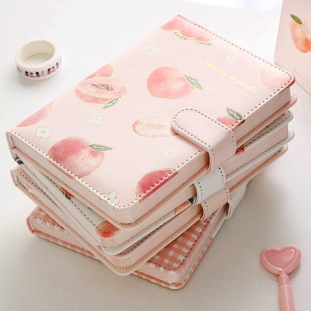 Pink notebook with peach and flower prints, rounded flap closure, and layered spine design