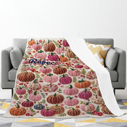 Personalized Halloween fleece throw blanket with pumpkin-floral pattern, draped on gray sofa