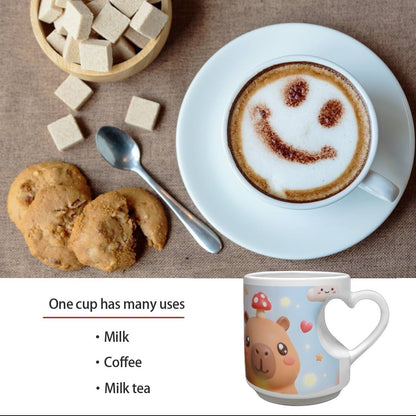 White ceramic character mug with heart handle; capybara face graphic on blue.